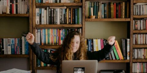 woman in black long sleeve shirt sitting in front of silver macbook