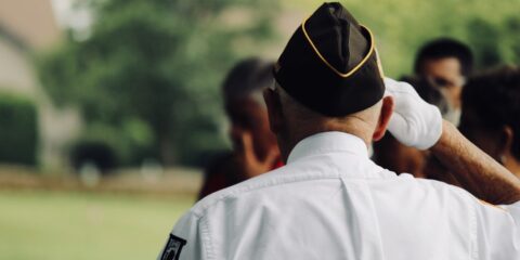 man wearing white uniform saluting
