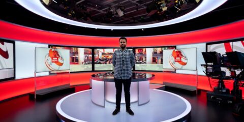 woman in black and white checkered dress shirt standing on white round table