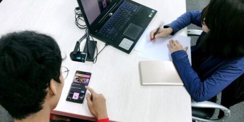 person in blue long sleeve shirt using black laptop computer