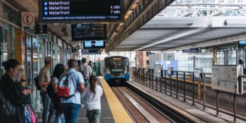 a group of people waiting for a train at a train station