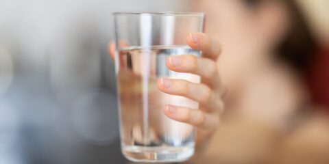 person holding clear drinking glass