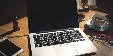 A laptop computer sitting on top of a wooden desk