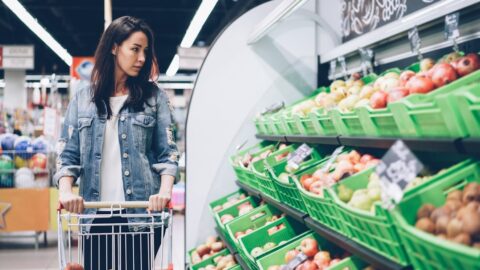 Woman shops for produce at a supermarket.