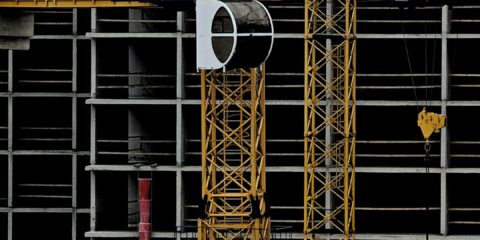 a yellow crane sitting on top of a building under construction