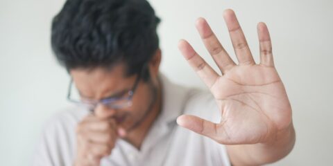 a man holding his hand up in front of his face