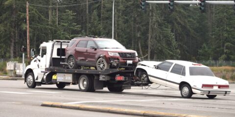 A tow truck towing a car on the road