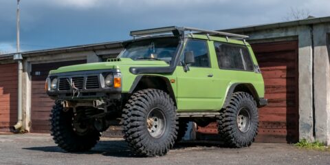 a green jeep parked in front of a building