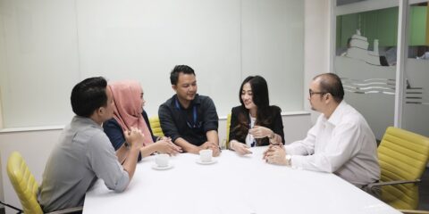 a group of people sitting around a white table