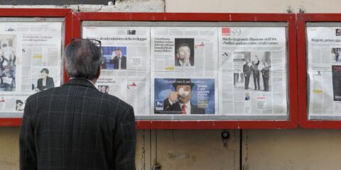 man reading newspaper in bulletin board