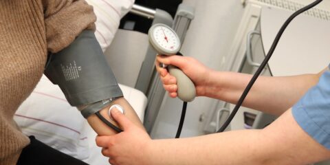 A person with a blood pressure device in their hand
