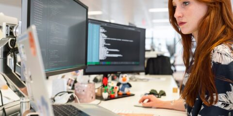 woman in green shirt sitting in front of computer