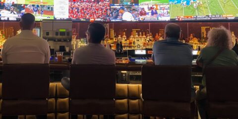 a group of people sitting at a bar watching tv