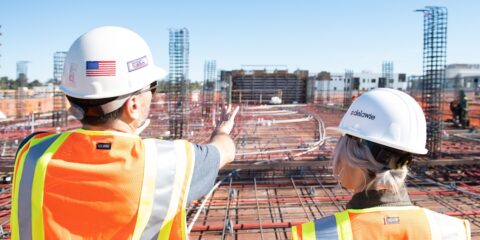 man in white hard hat standing on brown wooden dock during daytime