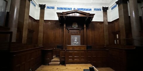 an empty courtroom with wooden paneling and columns