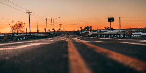 silhouette of people walking on road during sunset