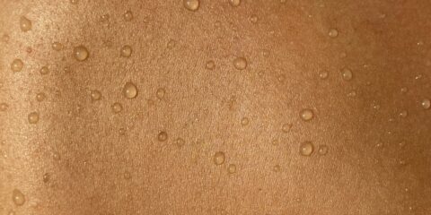 A man's back with water drops on it