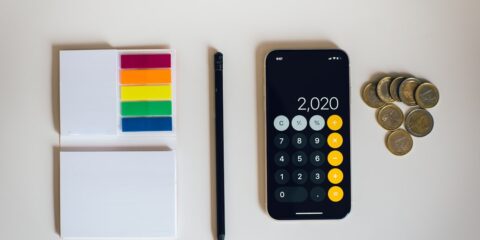 black iphone 4 beside black and silver remote control