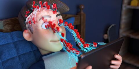 a person laying in a bed with a tablet