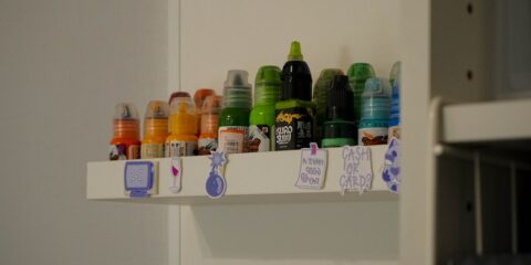 a shelf filled with lots of different colored bottles