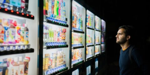 man on front of vending machines at nighttime