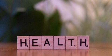 A wooden block spelling the word health on a table