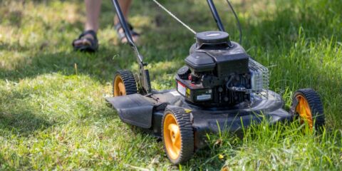 a person mowing the grass with a lawn mower