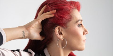 In-Person Study – Hearing Aids (New York City, NY) – Earn $250 a woman with red hair is putting her hair in a ponytail