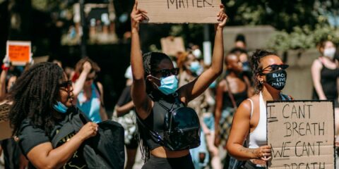 group of women in black and white tank top holding brown wooden board during daytime
