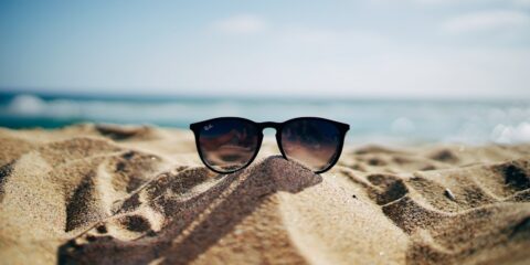 New Focus Group Updates Coming Monday black Ray-Ban Wayfarer sunglasses on beach sand
